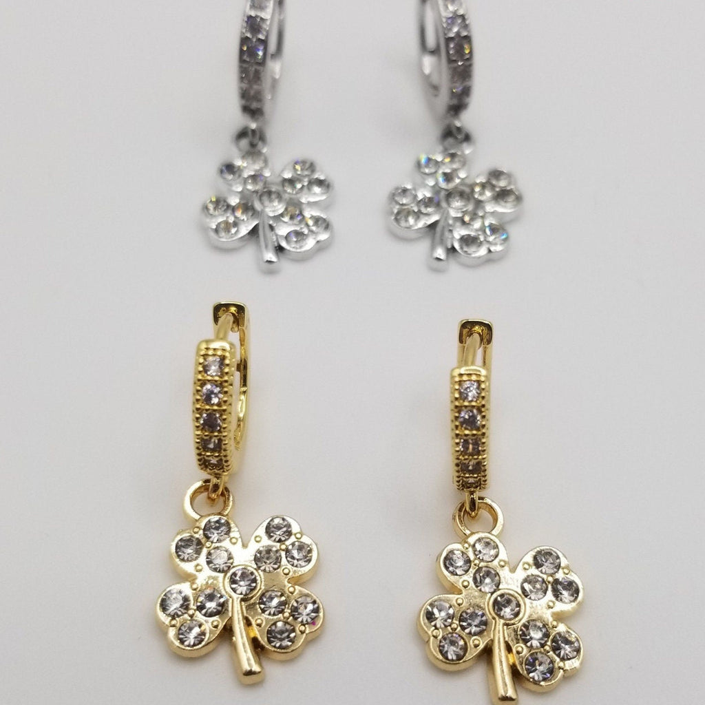 Gold and silver clover shaped earrings with cubic zirconia detailing on charms and Huggie closures.