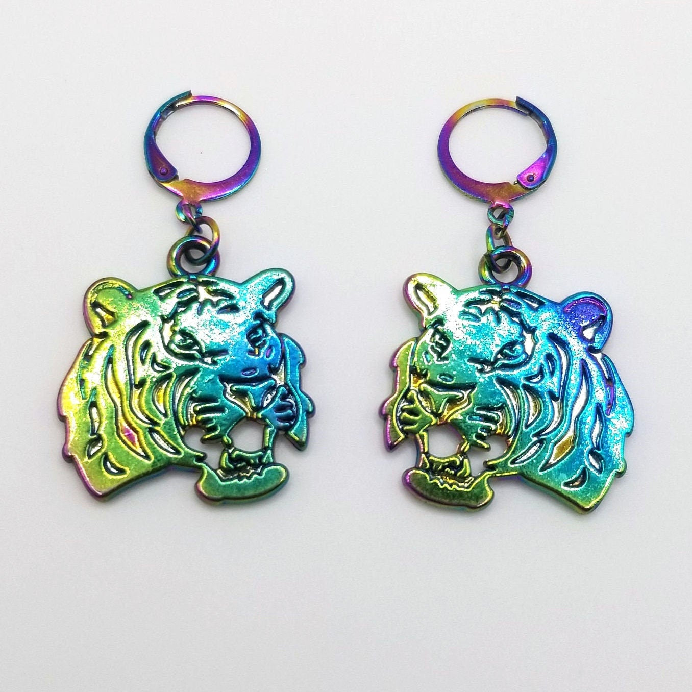 rainbow finish tiger-shaped earrings with a multicolored, iridescent finish on a white background.